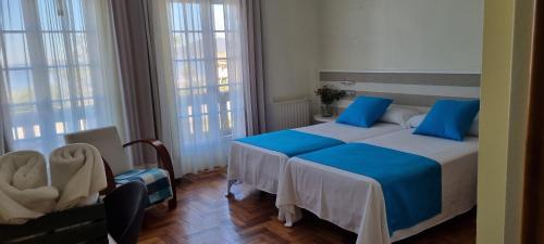 a bedroom with two beds and two windows at Hotel Miramar Playa America Nigran in Playa América