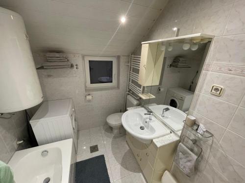 ein weißes Bad mit einem Waschbecken und einem WC in der Unterkunft Apartma Marni in Kranjska Gora