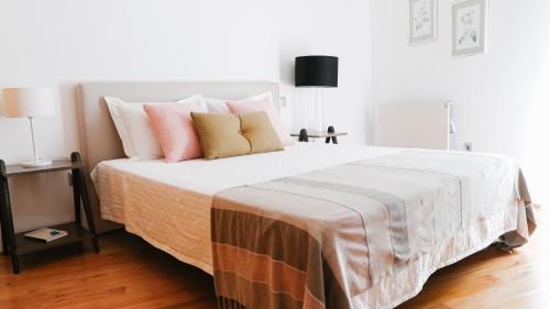 a bedroom with a large bed with pink and orange pillows at Quinta de Fiães in Vilar de Maçada