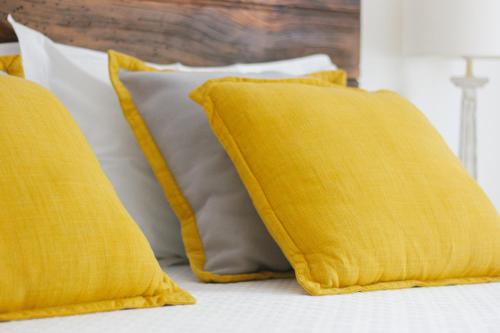 two yellow pillows are sitting on a bed at Quinta de Fiães in Vilar de Maçada