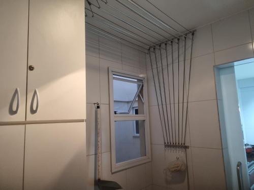 a bathroom with a window and a shower at Apartamento Frente para o Mar - Varandão com Blindex - Vista Total para o Mar - 1 Suite e mais 2 Quartos-Ar Condicionado - 2 Vagas - BEIRA MAR - 70 metros da Praia ,TVS SMART GERAL -WI-FI -DISNEY PLUS-OUTROS- PORTARIA 24 HORAS-KIT PRAIA 4 PESSOAS in Guarapari
