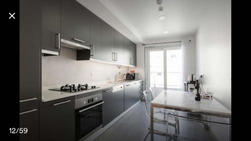 a kitchen with gray cabinets and a counter top at Modern Apartment for Family and Group of Friends in Sacavém