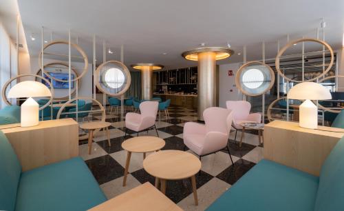 a salon with chairs and tables and mirrors at Medplaya Hotel Pez Espada in Torremolinos