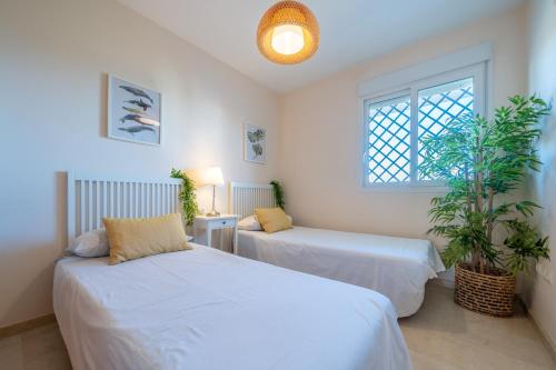 1 dormitorio con 2 camas y ventana en Apartamento con vistas al mar en Manilva Playa, en Manilva