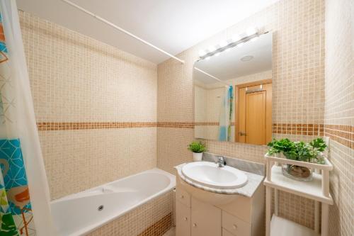 a bathroom with a tub sink and a mirror at Apartamento con vistas al mar en Manilva Playa in Manilva