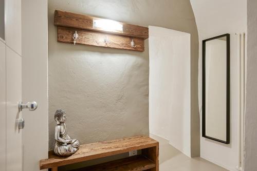 una estatua sentada en un banco de madera al lado de una puerta en KARINA Lauben Lodge, en Egna