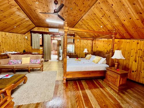 a bedroom with a bed and a couch and a table at Villa Chez Batista in Takamaka