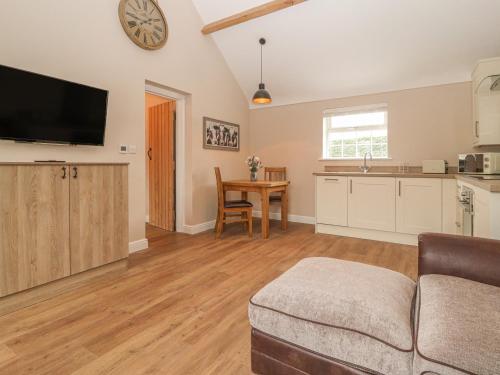 a living room with a couch and a kitchen at The Hay Barn in Chester