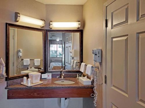 La salle de bains est pourvue d'un lavabo et d'un grand miroir. dans l'établissement Quality Inn Santa Nella on I-5, à Santa Nella