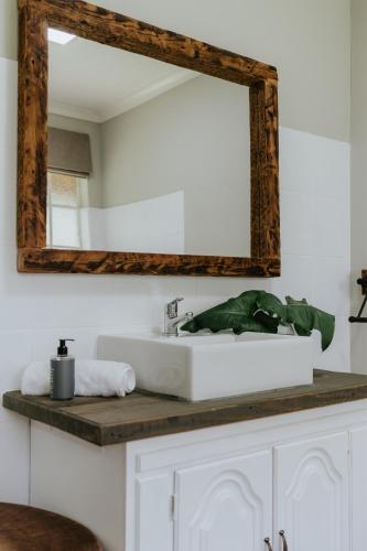 a bathroom with a white sink and a mirror at Breathe River Retreat in Parys