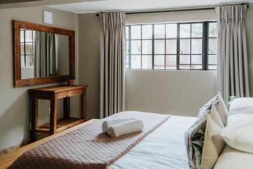 a bedroom with a bed with a mirror and a window at Breathe River Retreat in Parys