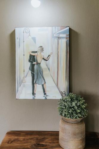a painting hanging on a wall with a woman dancing at Breathe River Retreat in Parys