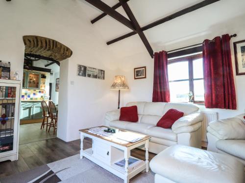 a living room with a white couch and a table at Y Stabl in Fishguard