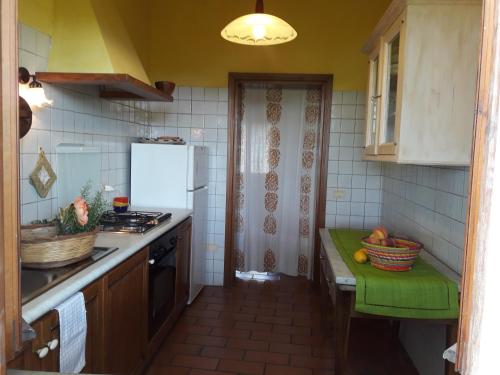 a kitchen with a refrigerator and a table with fruits on it at Ca' le Suore in Cagli