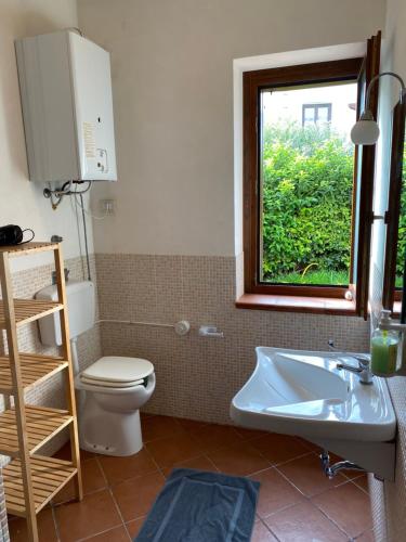 baño con aseo y lavabo y ventana en Alice Kite Resort en Marsala