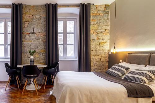 a bedroom with a bed and a table with chairs at Romantic studio in the heart of Trieste in Trieste