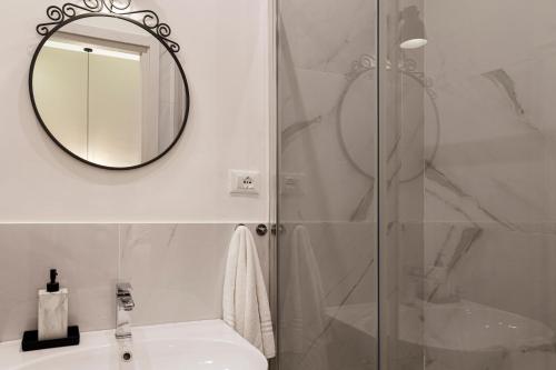 ein Bad mit einer Dusche, einem Waschbecken und einem Spiegel in der Unterkunft Romantic studio in the heart of Trieste in Triest