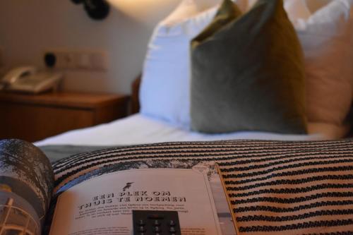 un libro seduto sopra un letto con un cuscino di Hotel Atlanta a Valkenburg