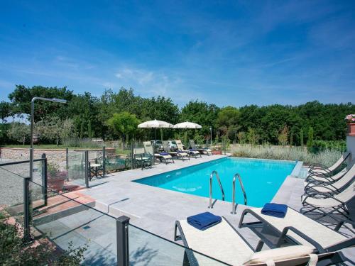 a swimming pool with chaise lounge chairs and a resort at Belvilla by OYO Villa Severina in Cortona