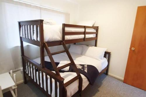 a bedroom with a bunk bed with white pillows at Cheerful 3BR Home With Free WiFi & Netflix in Auckland