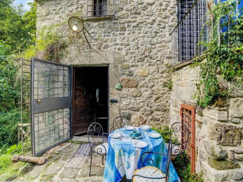 a table and chairs in front of a stone building at Belvilla by OYO Mulino in Piana di Forcella