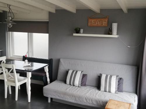 sala de estar con sofá y mesa en Cosy vacation home near the beach, en Egmond aan Zee