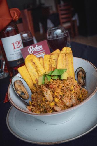 a bowl of food with rice and seafood and bread at Hotel Bachue in Barrancabermeja