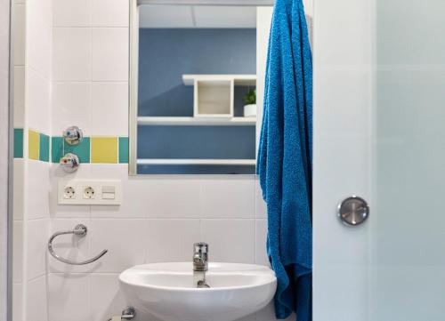 ein Badezimmer mit einem Waschbecken und einem blauen Handtuch in der Unterkunft Albergue Residencia Larraona in Pamplona