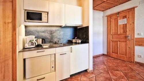 a kitchen with a sink and a microwave at Apart Gabriele - Pure Alpin Style in Sankt Anton am Arlberg