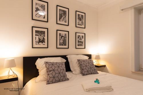 Frontaal zeezicht "Martinique" في أوستند: غرفة نوم بسرير بأربع صور على الحائط
