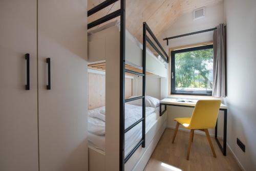 a tiny house with a desk and a yellow chair at Demänová Rezort in Liptovský Mikuláš