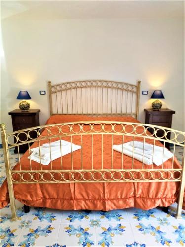 a bedroom with a bed with an orange bedspread at Residenza Villa Spagnola in Parghelia