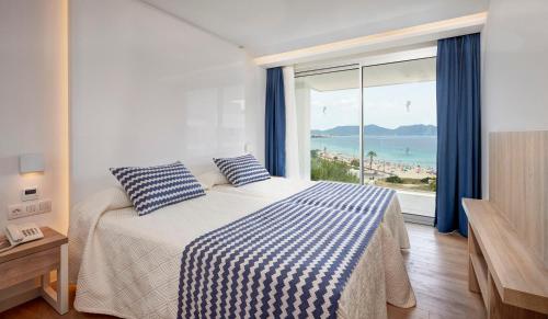 a bedroom with a bed with a view of the ocean at Hipotels Bahia Cala Millor - Adults Only in Cala Millor