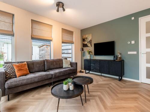 a living room with a couch and a flat screen tv at Holiday Home in De Koog with Sauna and Garden in Westermient