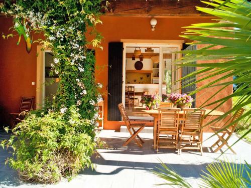 una casa con patio con mesa y sillas en Magnificent holiday home with private pool, en Fréjus
