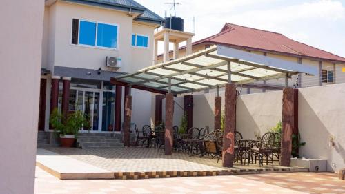 a patio with chairs and tables in a house at LaV ROYAL HOTEL in Kumasi