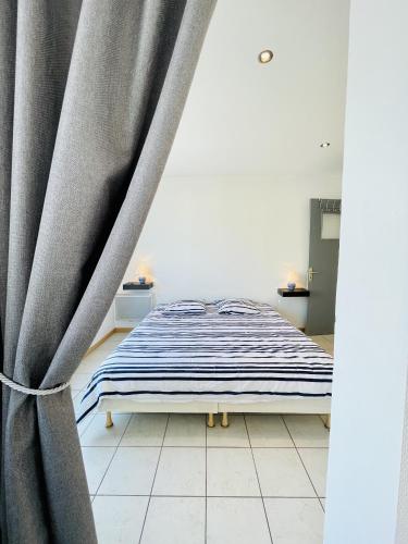 - un lit avec rideau dans une chambre dans l'établissement Residence Louis Place du Marche, à Bains-les-Bains