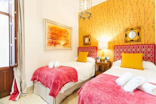 2 camas en una habitación de color amarillo y rojo en New with height- 2Bd 1Bth- Pajaritos, en Sevilla