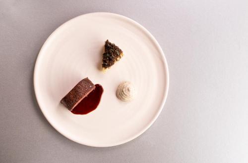 a white plate with a piece of cake and sauce at The Queensberry Hotel in Bath