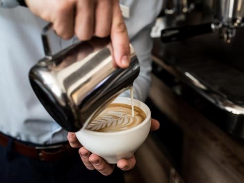 a person is holding a cup of coffee at Hotel Edison Poznań Lotnisko Ławica in Baranowo