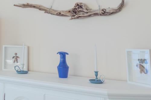 a white mantle with blue vases on it at La finestra sul mare in Ospedaletti