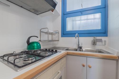 a kitchen with a stove and a sink at La finestra sul mare in Ospedaletti