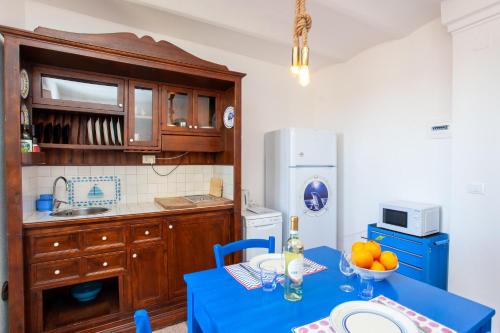 a kitchen with a table with a blue table cloth at Hora Mare in Orosei