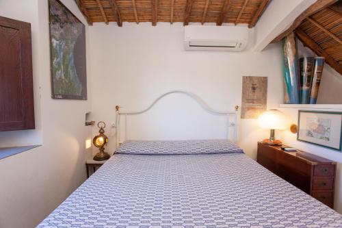 a bedroom with a bed with a blue and white bedspread at Hora Mare in Orosei