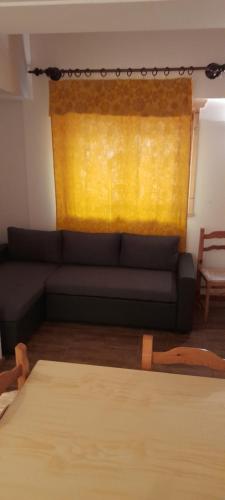 a living room with a couch and a yellow window at Fattoria Meneguto Agriturismo Degasper Giorgio in Cortina dʼAmpezzo