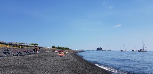 a group of people on a beach near the water at Stromboli Central Family Apartment - 3 Double Rooms in Stromboli