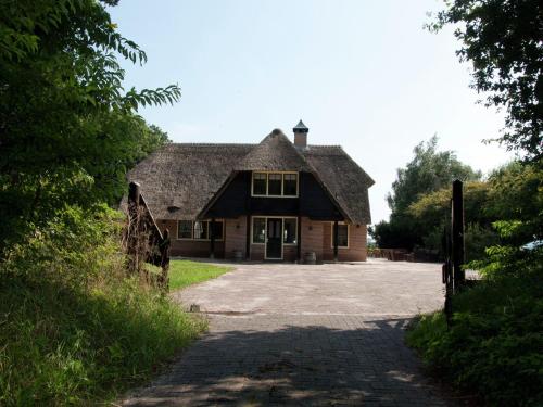 an old house with a stone driveway in front of it at Mansion in Nijensleek with Sauna & Garden in Nijensleek