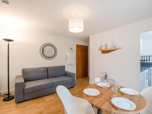 uma sala de estar com uma mesa e um sofá em Apartment in a residence by the sea em Port-en-Bessin-Huppain