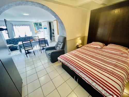 une chambre avec un lit, une chaise et une table dans l'établissement Residence Louis Le Lavoir, à Bains-les-Bains