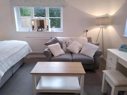 ein Wohnzimmer mit einem Sofa und einem Bett in der Unterkunft Brick Kiln Apartment in Campsey Ash